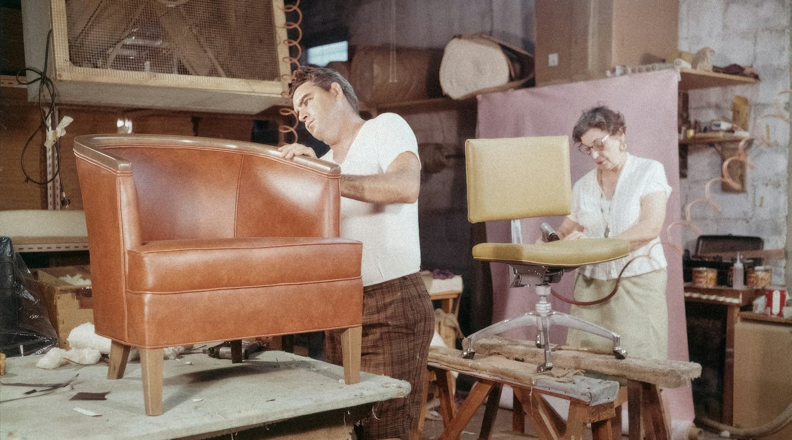 An upholsterer working on a leather chair